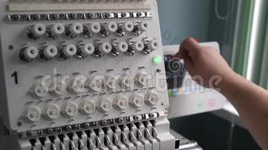一名工人正在用平板电脑编程一台数控缝纫机。 操作人员设置数控机床。